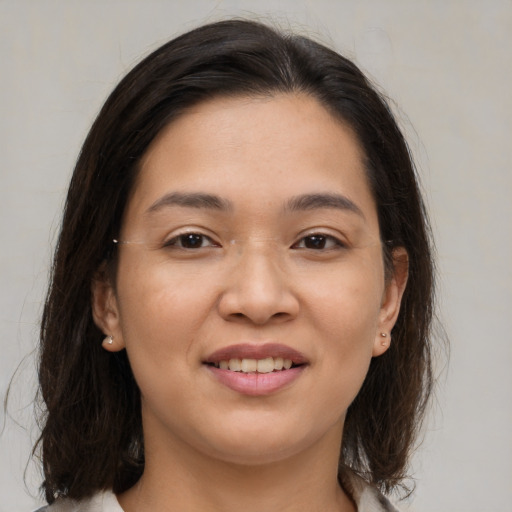 Joyful asian young-adult female with medium  brown hair and brown eyes