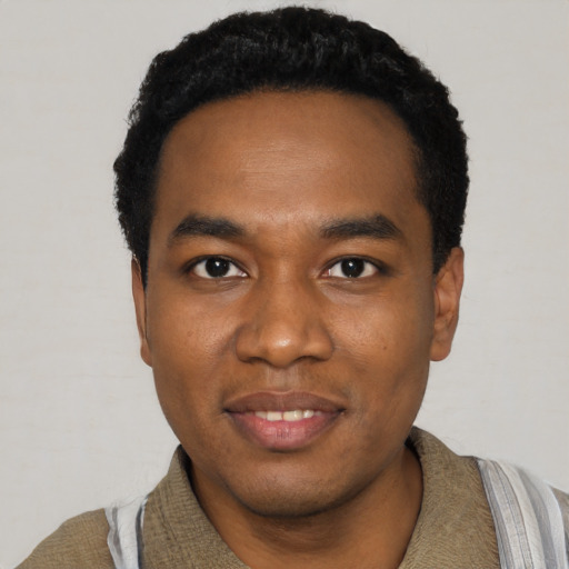 Joyful black young-adult male with short  black hair and brown eyes