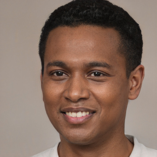 Joyful black young-adult male with short  black hair and brown eyes