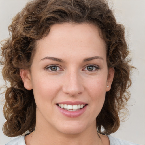 Joyful white young-adult female with medium  brown hair and green eyes