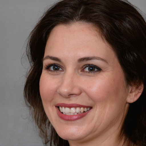 Joyful white adult female with medium  brown hair and brown eyes