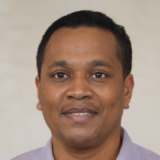 Joyful black adult male with short  black hair and brown eyes