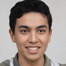 Joyful latino young-adult male with short  brown hair and brown eyes