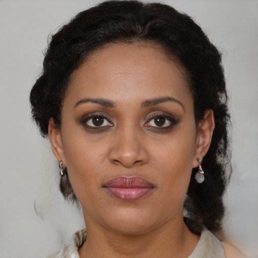 Joyful black adult female with medium  brown hair and brown eyes