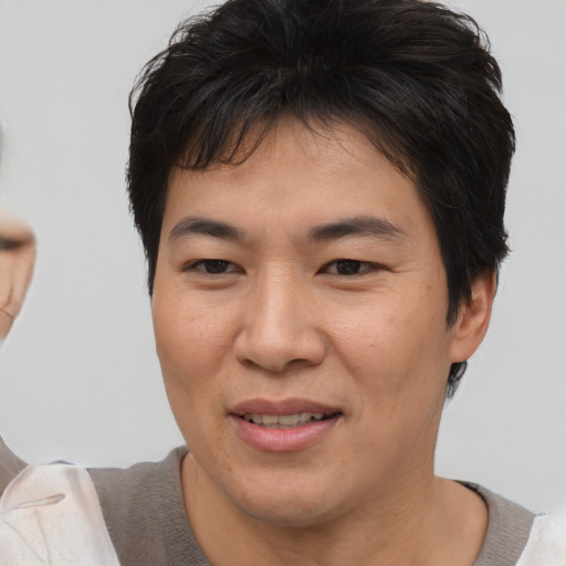 Joyful asian young-adult male with short  brown hair and brown eyes