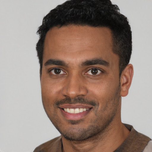 Joyful white young-adult male with short  black hair and brown eyes