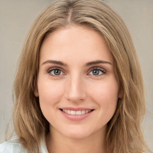 Joyful white young-adult female with long  brown hair and green eyes