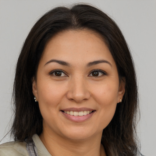 Joyful latino young-adult female with medium  brown hair and brown eyes