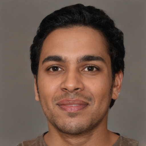 Joyful latino young-adult male with short  black hair and brown eyes