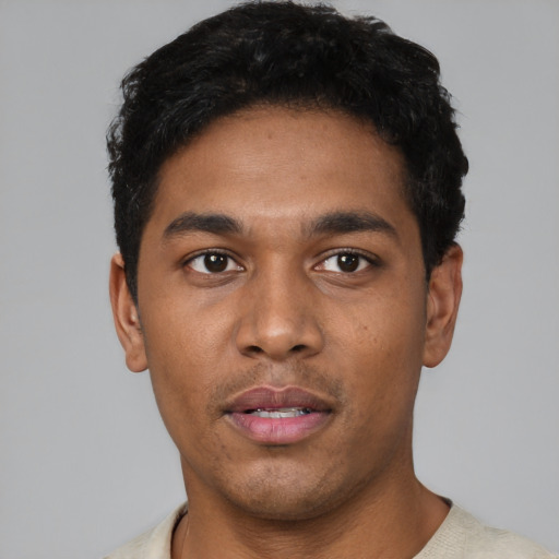 Joyful latino young-adult male with short  black hair and brown eyes