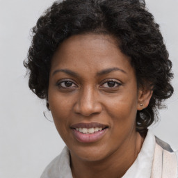 Joyful black young-adult female with long  brown hair and brown eyes