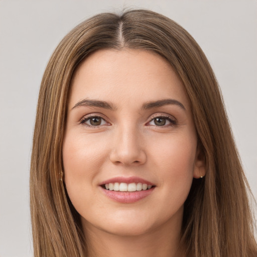 Joyful white young-adult female with long  brown hair and brown eyes