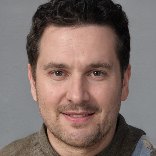 Joyful white adult male with short  brown hair and grey eyes