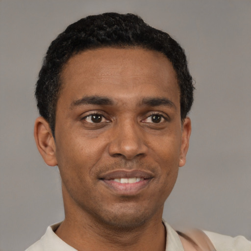 Joyful black young-adult male with short  black hair and brown eyes