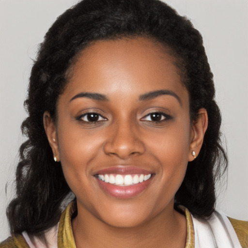 Joyful black young-adult female with long  brown hair and brown eyes