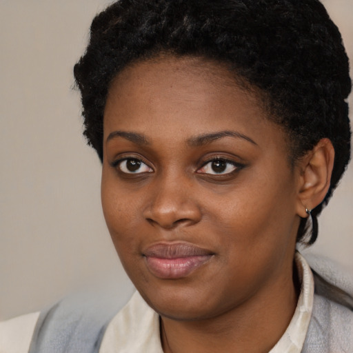 Joyful black young-adult female with short  brown hair and brown eyes