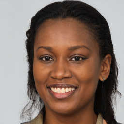 Joyful black young-adult female with long  brown hair and brown eyes