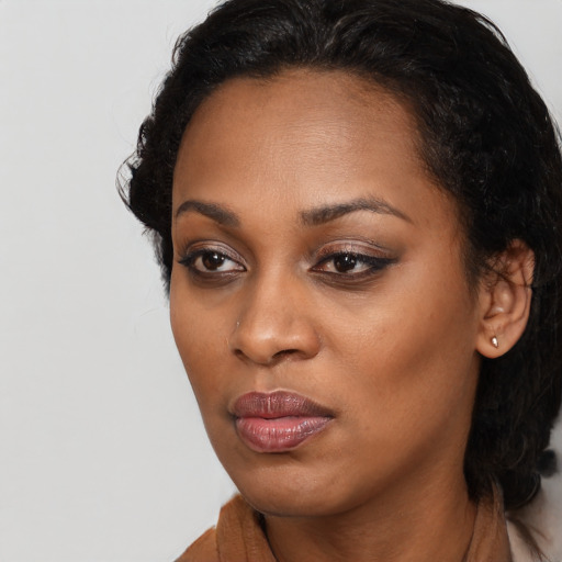 Joyful black young-adult female with long  black hair and brown eyes