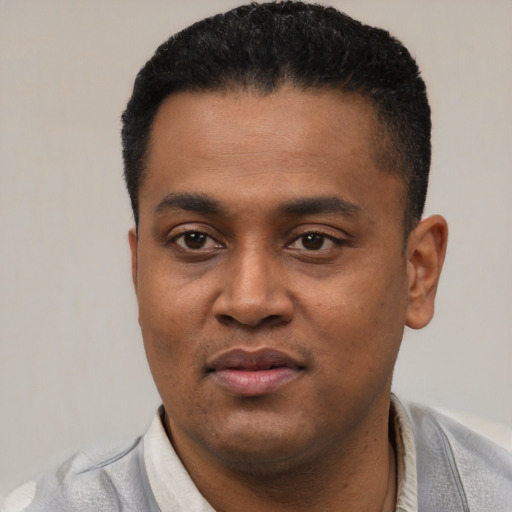 Joyful latino young-adult male with short  black hair and brown eyes