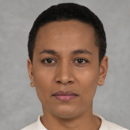 Joyful black young-adult female with short  black hair and brown eyes