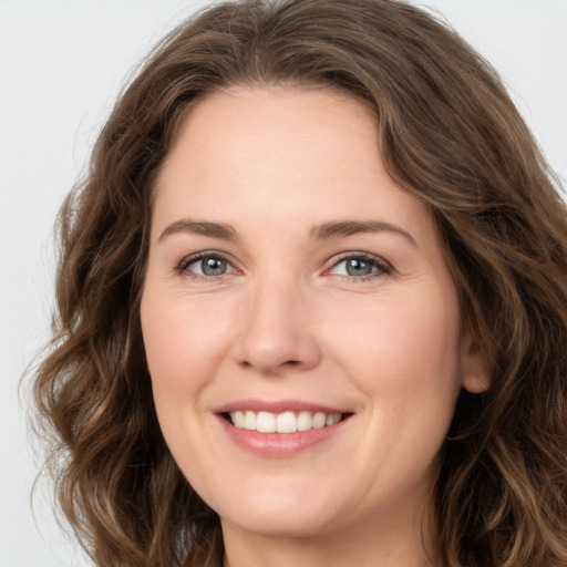 Joyful white young-adult female with long  brown hair and green eyes