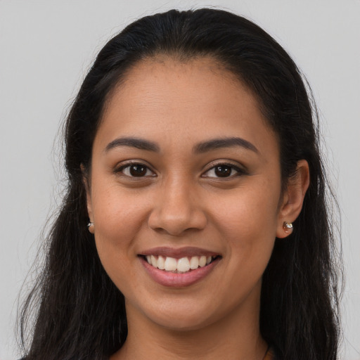 Joyful latino young-adult female with long  brown hair and brown eyes