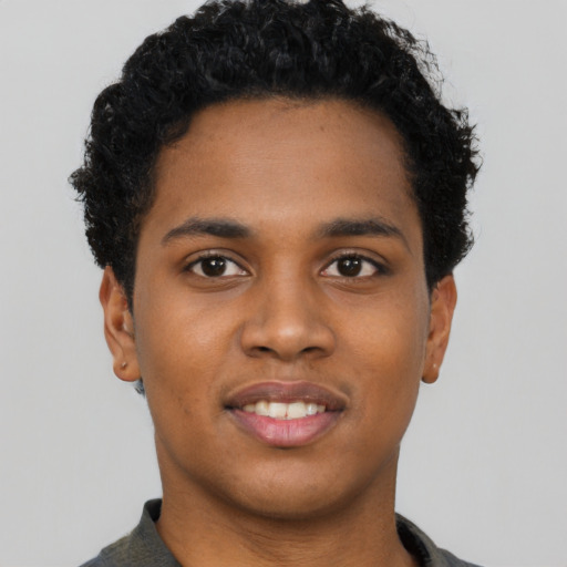 Joyful black young-adult male with short  black hair and brown eyes