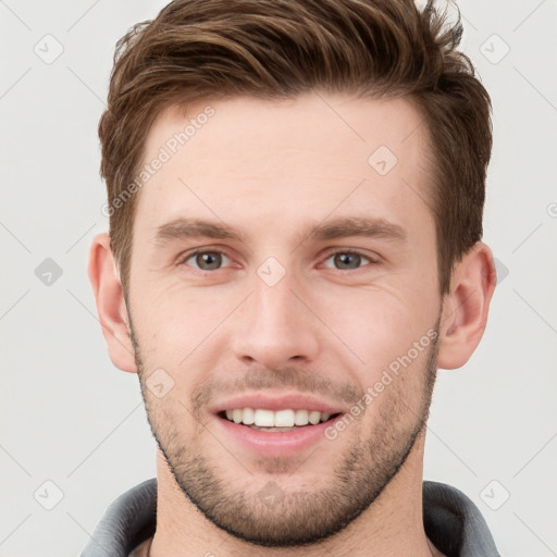 Joyful white young-adult male with short  brown hair and grey eyes