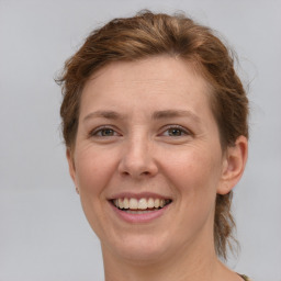 Joyful white adult female with medium  brown hair and green eyes