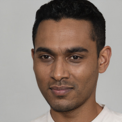 Joyful black young-adult male with short  black hair and brown eyes