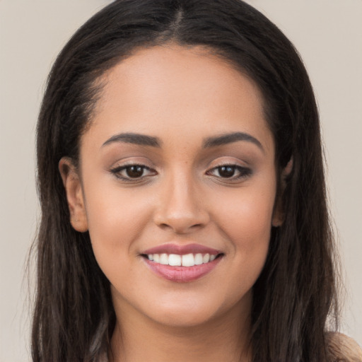 Joyful latino young-adult female with long  brown hair and brown eyes