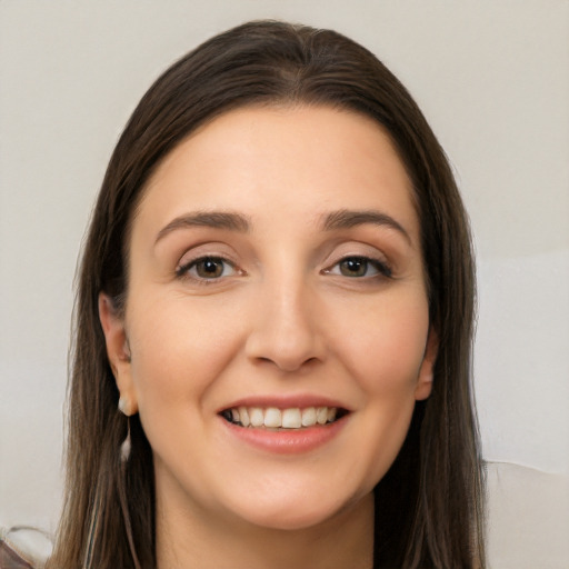 Joyful white young-adult female with long  brown hair and brown eyes