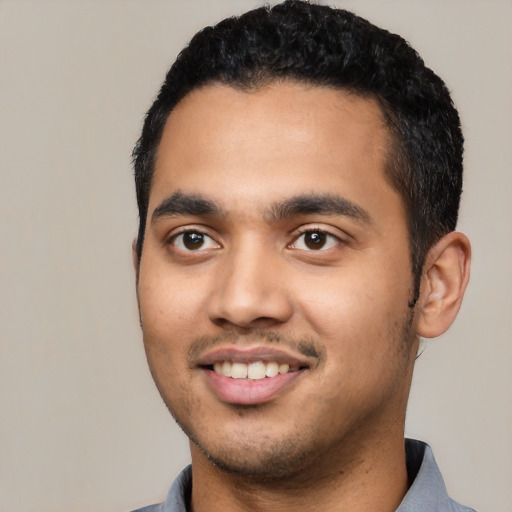 Joyful latino young-adult male with short  black hair and brown eyes