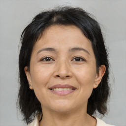 Joyful asian adult female with medium  brown hair and brown eyes