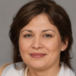 Joyful white adult female with medium  brown hair and brown eyes