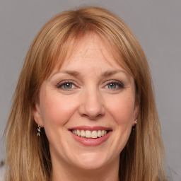 Joyful white adult female with long  brown hair and grey eyes