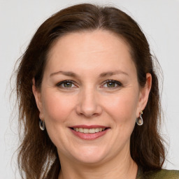 Joyful white adult female with long  brown hair and grey eyes