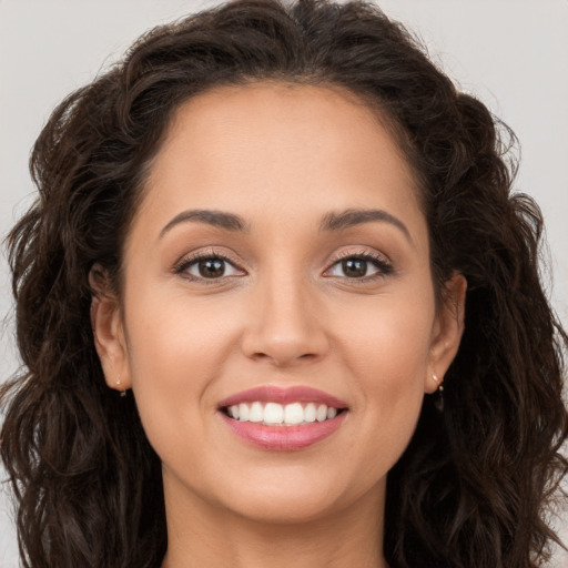 Joyful white young-adult female with long  brown hair and brown eyes