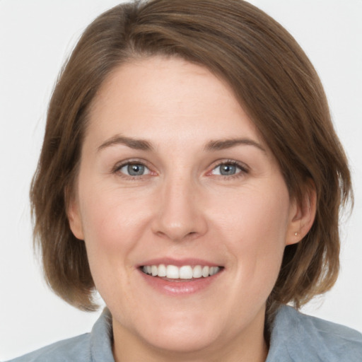 Joyful white adult female with medium  brown hair and grey eyes