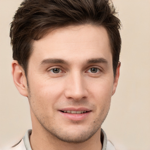 Joyful white young-adult male with short  brown hair and grey eyes