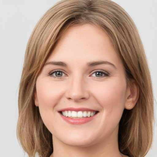 Joyful white young-adult female with medium  brown hair and green eyes