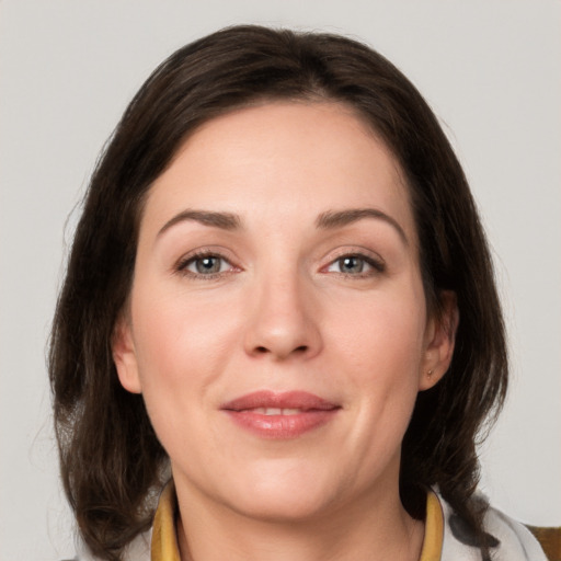 Joyful white young-adult female with medium  brown hair and grey eyes