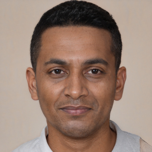Joyful black young-adult male with short  black hair and brown eyes