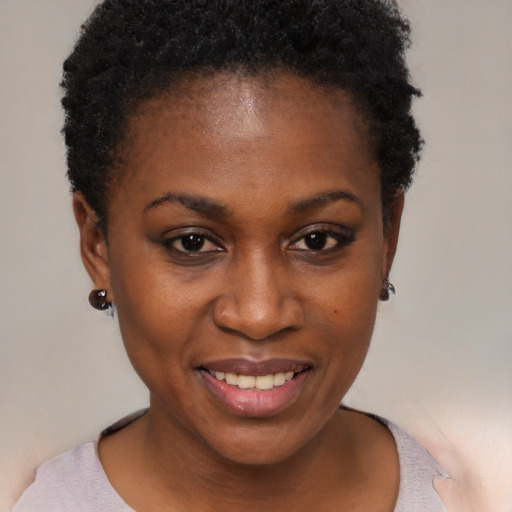 Joyful black young-adult female with short  black hair and brown eyes