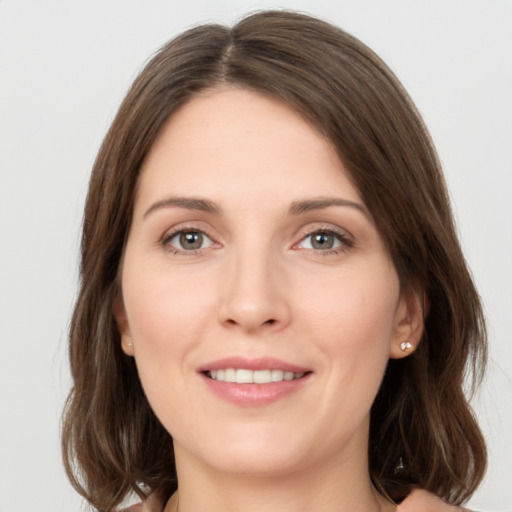 Joyful white young-adult female with medium  brown hair and green eyes