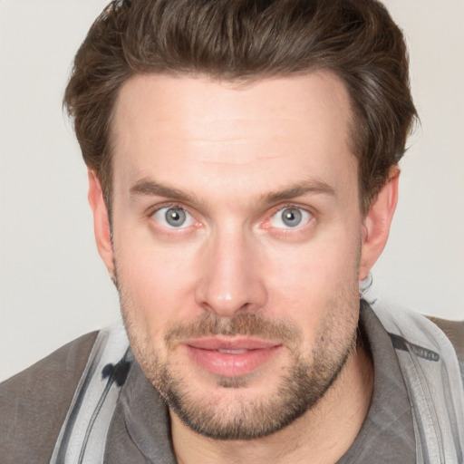 Joyful white young-adult male with short  brown hair and blue eyes