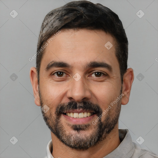 Joyful white adult male with short  black hair and brown eyes