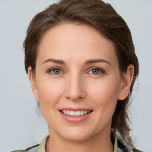 Joyful white young-adult female with medium  brown hair and grey eyes