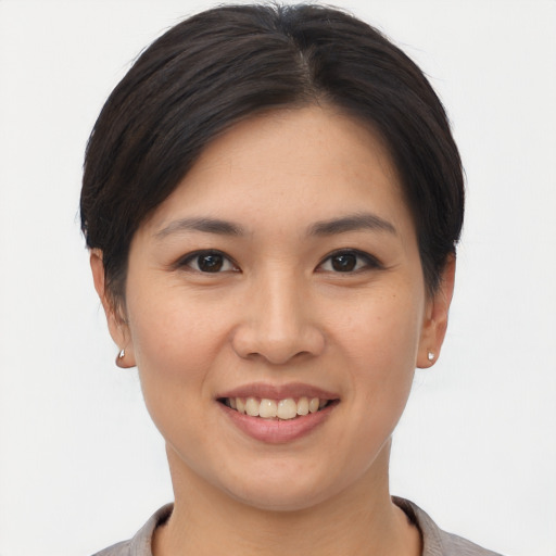 Joyful asian young-adult female with short  brown hair and brown eyes