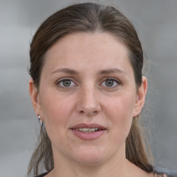 Joyful white adult female with medium  brown hair and grey eyes